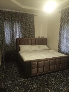 a large bed in a room with avertisement at Country Spire Apartments in Gwarinpa