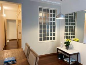 a dining room with a table and a window at Apartamento Orla Praia do Canto in Vitória