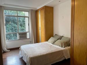 a bedroom with a large bed and a window at Apartamento Orla Praia do Canto in Vitória