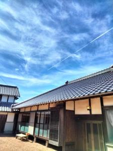 um edifício com um céu azul ao fundo em 農家古民家ねこざえもん奥屋敷 Nekozaemon-Gest house em Nishiwada