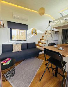 ein Wohnzimmer mit einem blauen Sofa und einem Tisch in der Unterkunft Tiny House Yalikavak Natural Garden in Yalıkavak
