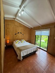 a bedroom with a bed and a large window at Hostal Raioha in Hanga Roa