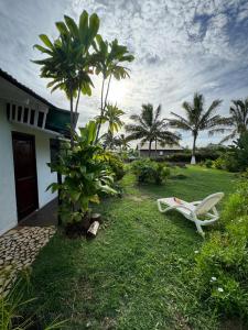 una silla blanca sentada en el césped junto a una casa en Hostal Raioha, en Hanga Roa