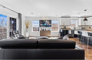 a living room with a black couch and a kitchen at Cityscape Unit 2 in Newark