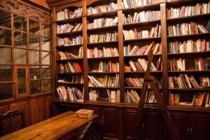 a library with a wooden table and shelves of books at Casa Carondelet Spanish Colonial Home in Quito