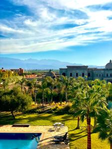 Blick auf ein Resort mit Pool und Palmen in der Unterkunft Very Nice villa with 5 rooms with private bathtooms all confort ourika Road kilomètre 9 in Marrakesch