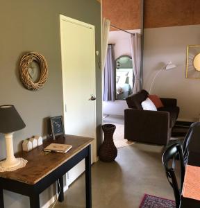 una sala de estar con mesa y una habitación con sofá en Cosy Country Stay B&B, en Matamata