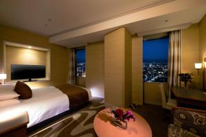 a hotel room with a bed and a large window at Hotel Nikko Kanazawa in Kanazawa