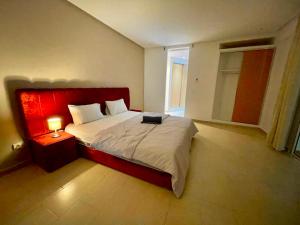 Schlafzimmer mit einem großen Bett mit einem roten Kopfteil in der Unterkunft Very Nice villa with 5 rooms with private bathtooms all confort ourika Road kilomètre 9 in Marrakesch
