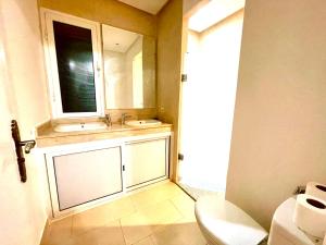 ein Badezimmer mit einem Waschbecken, einem Spiegel und einem WC in der Unterkunft Very Nice villa with 5 rooms with private bathtooms all confort ourika Road kilomètre 9 in Marrakesch
