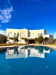 une grande piscine en face d'un bâtiment dans l'établissement Very Nice villa with 5 rooms with private bathtooms all confort ourika Road kilomètre 9, à Marrakech