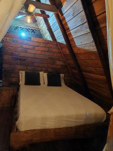 a bed in a room with a wooden wall at Alojamiento Rural Altos del Molino in Los Andes