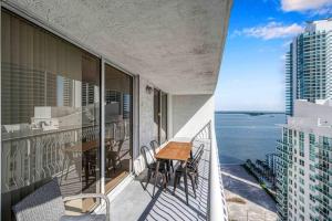 a balcony with a table and chairs and the ocean at Luxe 1 BDR •Brickell• Ocean View in Miami