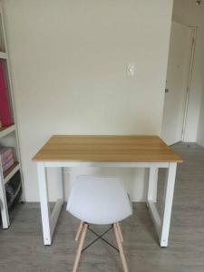 einen Holztisch mit einem weißen Stuhl in einem Zimmer in der Unterkunft Elise's Exclusive Escape - Amaia Altaraza San Jose Del Monte Bulacan in Tunkong Manga