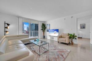 a white living room with a couch and a table at Luxe 1 BDR •Brickell• Ocean View in Miami