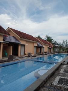uitzicht op een zwembad in een resort bij New Belitung Holiday Resort in Pasarbaru