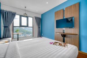 Un dormitorio con una cama grande y un televisor. en NATA-Căn hộ du lịch Nha Trang, en Nha Trang 267 fotos más