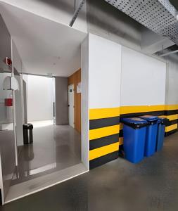 un pasillo con paredes amarillas y blancas y cubos de basura en Novissimo Apt Salvador, en Salvador