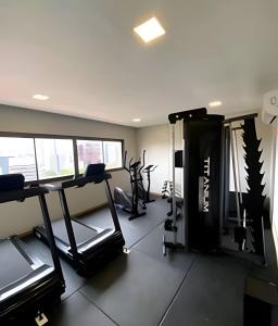 a gym with treadmills and machines in a room at Novissimo Apt Salvador in Salvador