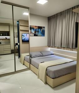 a bedroom with two beds and a tv in it at Novissimo Apt Salvador in Salvador