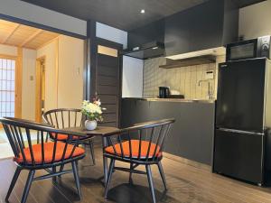 a kitchen with a table and chairs and a refrigerator at 京都駅そばの一棟貸し京町家 suiten shichijo 萃点七条 in Kyoto