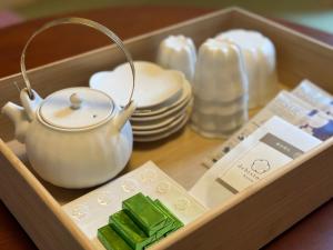uma bandeja de madeira com uma chaleira e pratos de chá em 京都駅そばの一棟貸し京町家 suiten shichijo 萃点七条 em Quioto