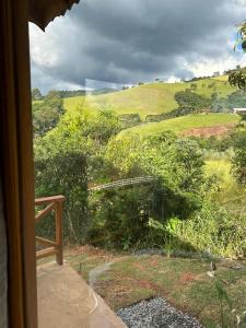 a view of a field from a window at Chalé Recanto das Estrelas in Monte Verde