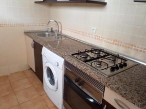 a kitchen with a stove top oven next to a sink at Résidence Al Cudia Smir - Plage Riffiyenne in Fnidek