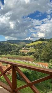 un puente de madera con vistas a la montaña en Chalé Recanto das Estrelas en Monte Verde
