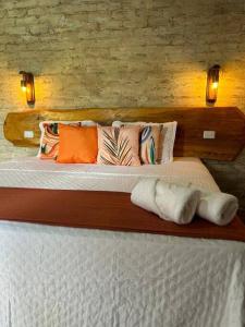 1 dormitorio con 1 cama con almohadas en Chalé Recanto das Estrelas, en Monte Verde