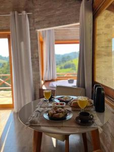 una mesa con dos platos de comida encima en Chalé Recanto das Estrelas en Monte Verde