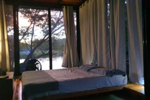 sypialnia z łóżkiem przed oknem w obiekcie Isla Mirabel, a unique private island experience! w mieście Granada