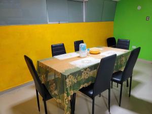 einen Tisch in einem Zimmer mit Stühlen und einem Tisch mit Tischtuch in der Unterkunft Apartamento Panorámico in Cajamarca