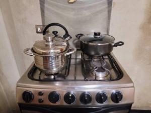 a stove top with two pots and pans on it at Apartamento Panorámico in Cajamarca