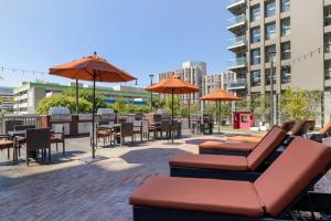a patio with tables and chairs and umbrellas at Downtown LA - Mamba Suite - Free Indoor Parking! in Los Angeles