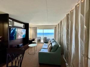 a living room with a couch and a television at Serenity Waikiki ! Luxury Ocean Suite ! in Honolulu