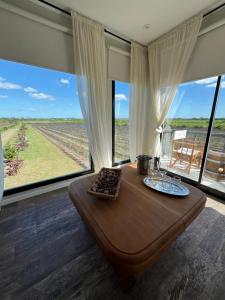 een kamer met een tafel en uitzicht op een veld bij Las Magnolias Bodega Boutique in Gualeguaychú