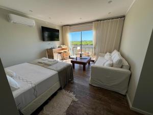 a bedroom with a bed and a couch and a television at Las Magnolias Bodega Boutique in Gualeguaychú +12 photos