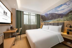 a hotel room with a large bed and a television at True Go Hotel - Shenzhen Futian Huaqiang North in Shenzhen