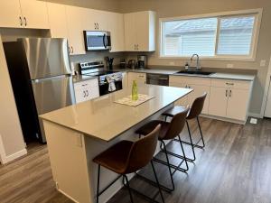 a kitchen with a large island with bar stools at Luxury Villa Home in Edmonton
