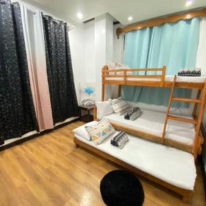 Matthew's Place Baguio city في باغيو: غرفة بسريرين بطابقين وأرضية خشبية