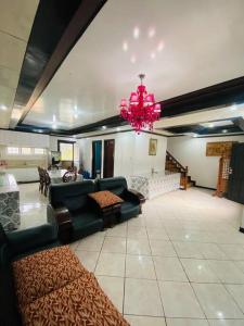 Matthew's Place Baguio city في باغيو: غرفة معيشة مع أريكة وثريا