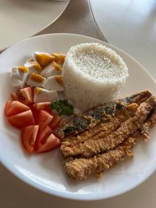 um prato branco de alimentos com arroz e legumes em AEON SUITES STAYCATION manage by ARIA HOTEL em Davao