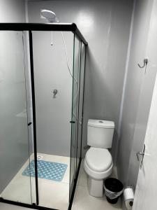 a bathroom with a toilet and a glass shower at Loft Lux 8 in Chapecó