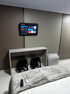 a bedroom with a bed and a tv on the wall at Loft Lux 8 in Chapecó