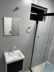 a bathroom with a sink and a mirror at Loft Lux 8 in Chapecó