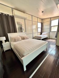 a bedroom with a large white bed and two windows at Katherine Farmstay Caravan Park in Katherine