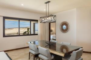 a dining room with a table and chairs and a mirror at Beachfront 2 Bdrm Condo in Exclusive Diamante Golf in Cabo San Lucas