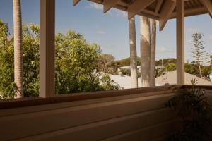 a porch with a view of a beach and palm trees at 28 Degrees Byron Bay - Adults Only in Byron Bay