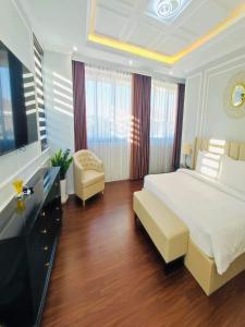 a bedroom with a large white bed and a television at Villa FLC 7 Ngủ Resort Hạ Long - Phòng Karaoke riêng in Ha Long